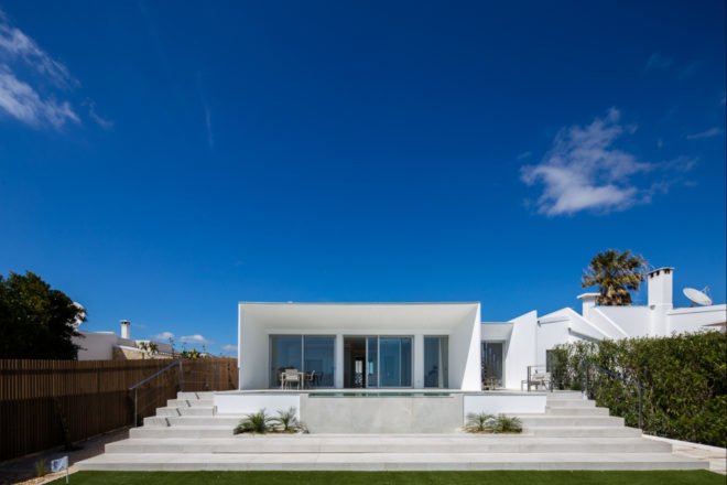 white cube-like building in front of stairs