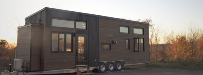 a wooden tiny home on wheels with windows