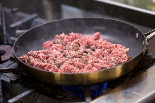 red plant-based meat in a skillet