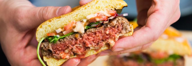 person holding medium-well veggie patty
