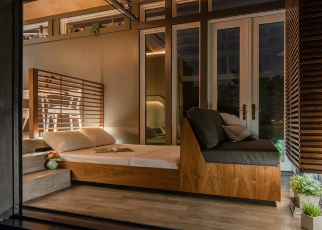 tiny home interior at night with gray sofa pushed out into a bed