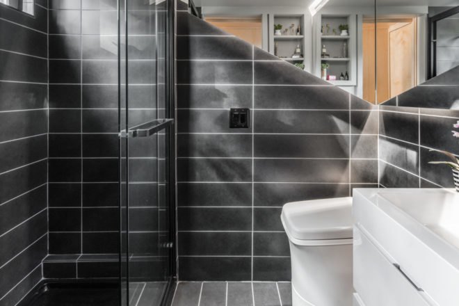 bathroom with dark gray tiles and glass shower