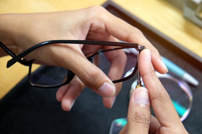 person repairing glasses