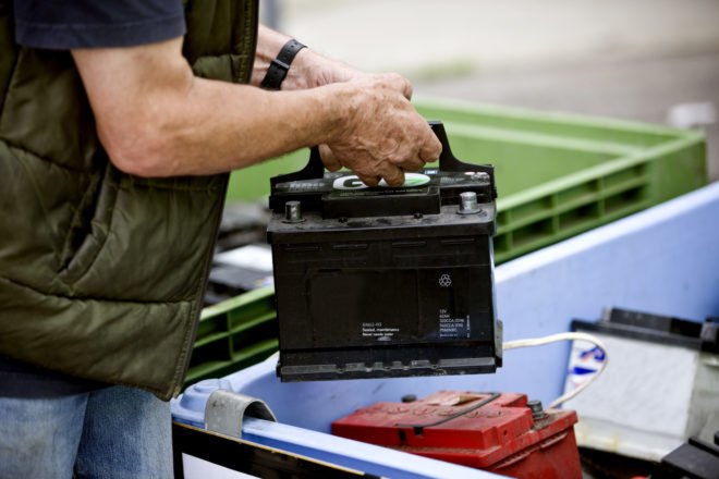 person recycling a car battery