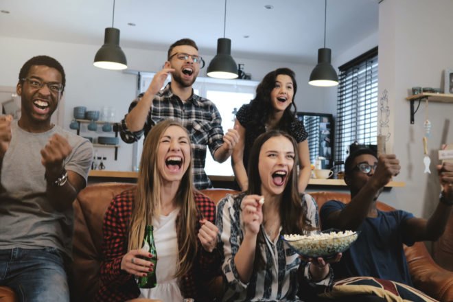 group of friends watching football and cheering