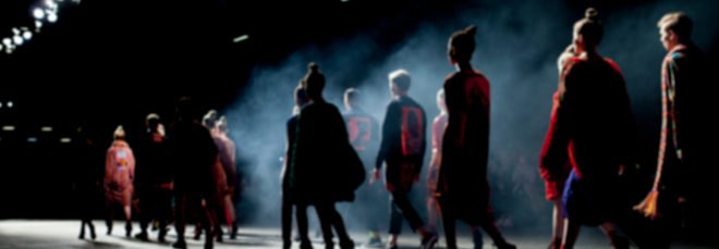 models walking on a foggy runway