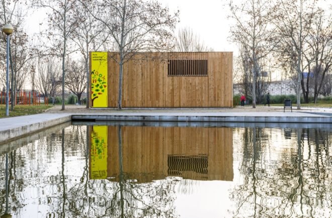 wood classroom building in front of a pond