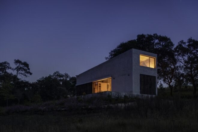 stone home with lights on inside at night
