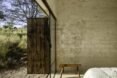 bedroom with stone walls and open wooden doors to the outside