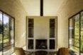 two chairs facing a shelving unit and fireplace