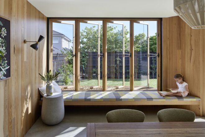 lounge area inside home with large windows and timber walls