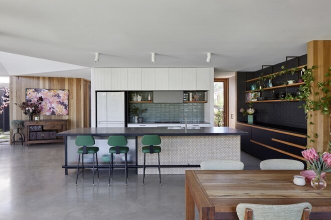 white kitchen cabinets with green tiles and surrounding black painted brick and wood