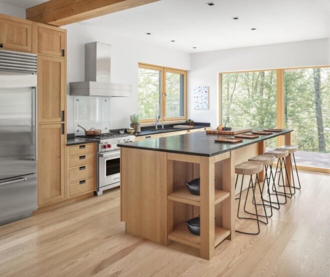 kitchen with light brown wood floors matching with cabinets with large windows letting sunlight into the home
