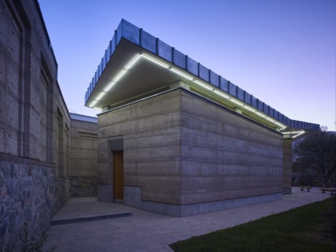 rammed earth building with green lighting