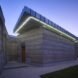 rammed earth building with green lighting