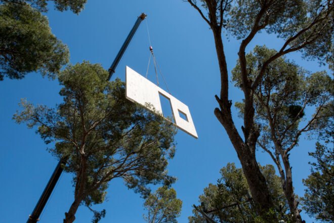 a wooden panel being lowered by a crane