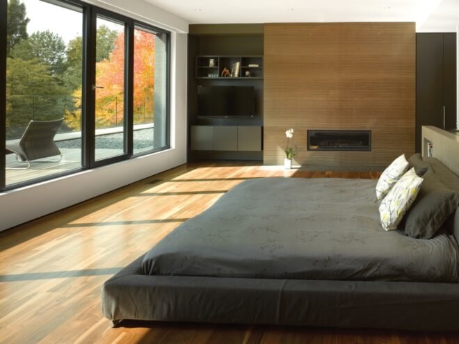 bedroom with gray bed and wood floors
