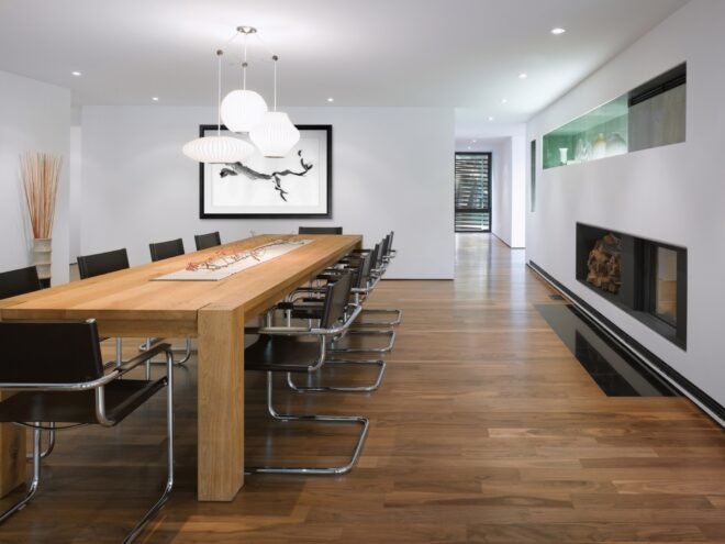 white room with long wood table near fireplace