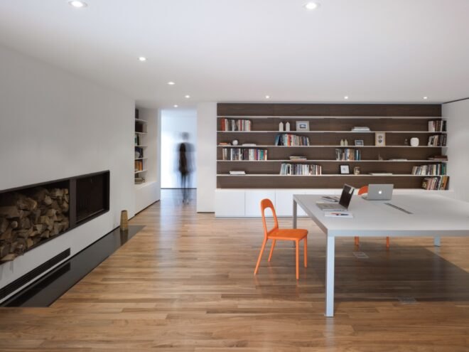 white room with large gray table and bookshelves