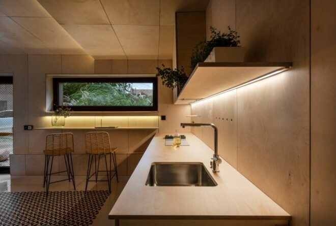 wood-lined kitchen with a metal sink and recessed lighting