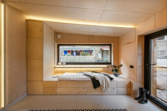 wood-lined interior with bed near a window