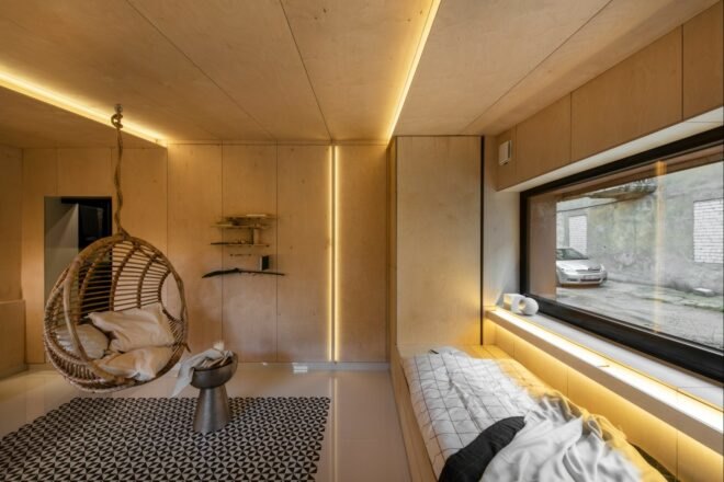 wood-lined studio with recessed lighting and hanging wicker chair
