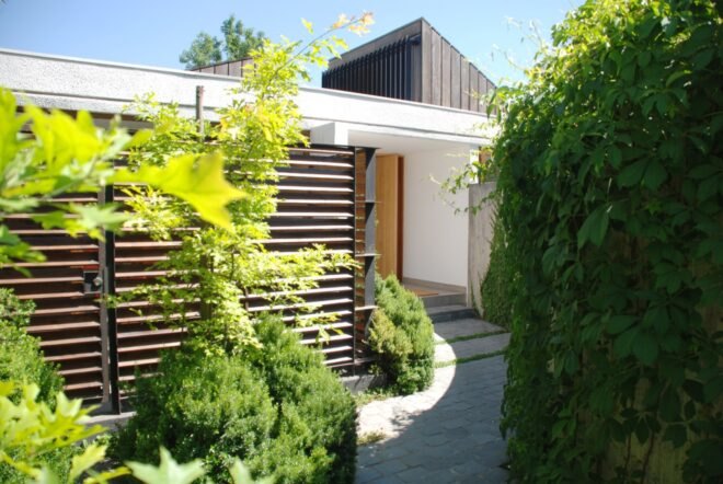 stone walkway to entrance of white home
