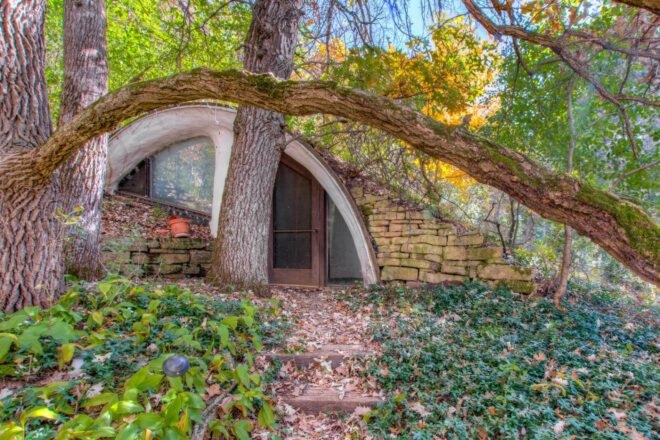 curved hobbit house with green roof