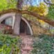 curved hobbit house with green roof