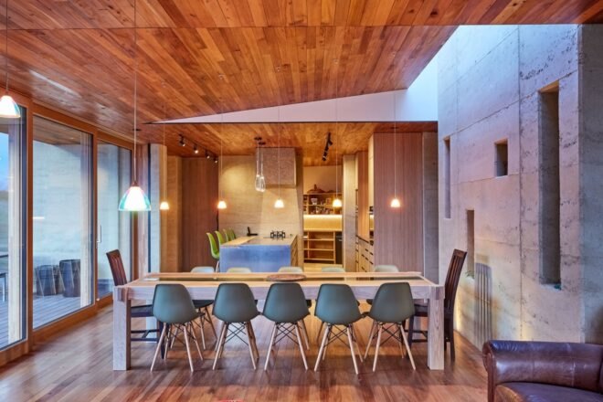 long dining table with many chairs in wood-lined room