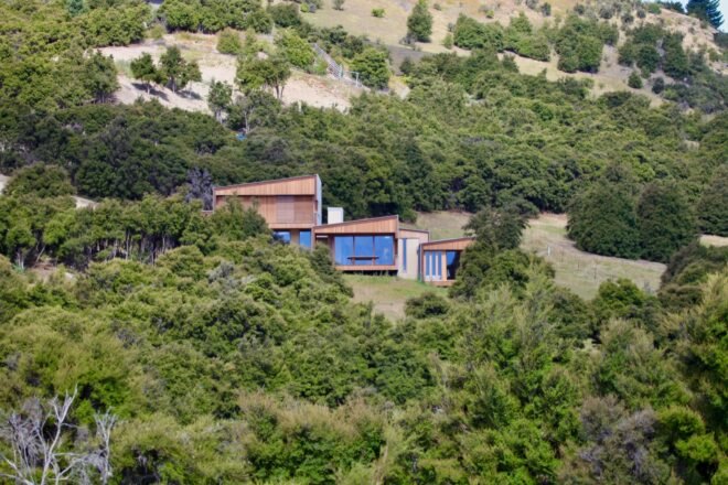 wooden home surrounded by trees and hills