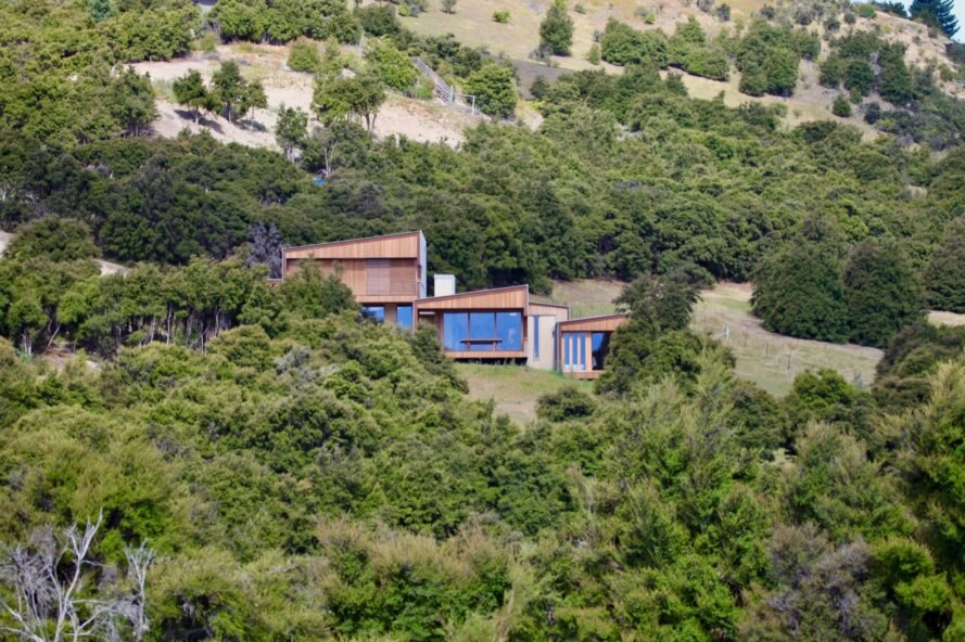 wooden home surrounded by trees and hills