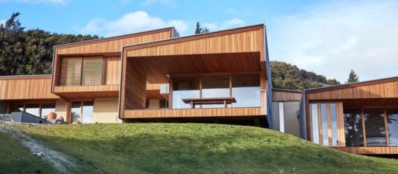 wooden and rammed earth home at the top of a hill