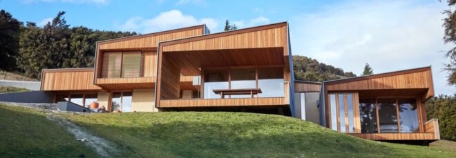 wooden and rammed earth home at the top of a hill