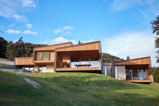 wooden and rammed earth home at the top of a hill