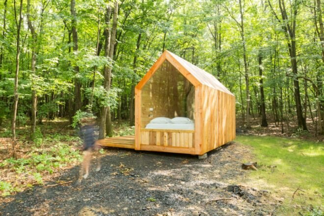 tiny wood cabin with pitched roof and glazed wall