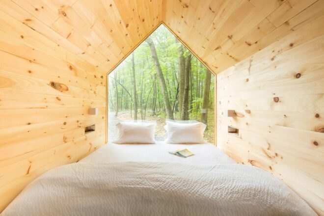 interior sleeping space with one bed in front of glazed wall