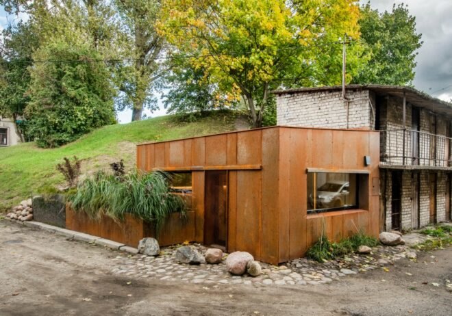 tiny corner garage clad in weathered metal