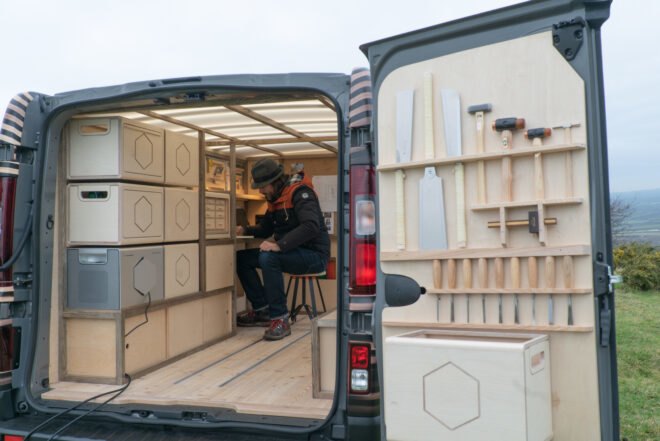 man sitting inside mobile woodworking station