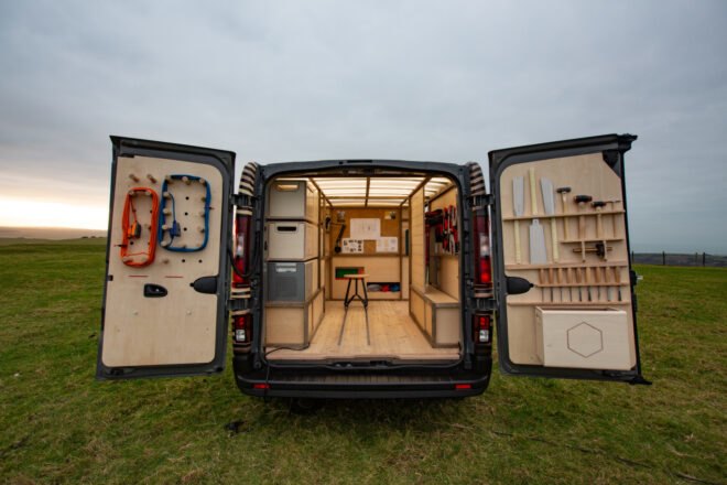 back of van with doors open to reveal woodworking shop