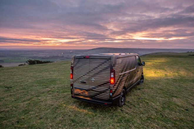 long dark van on expansive green land