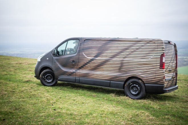 long dark van on expansive green land