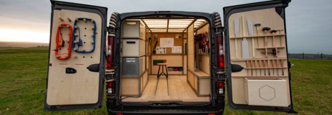 back of van with doors open to reveal woodworking shop