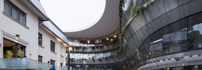 exterior of office building with modern design and greenery planted on the building's balconies