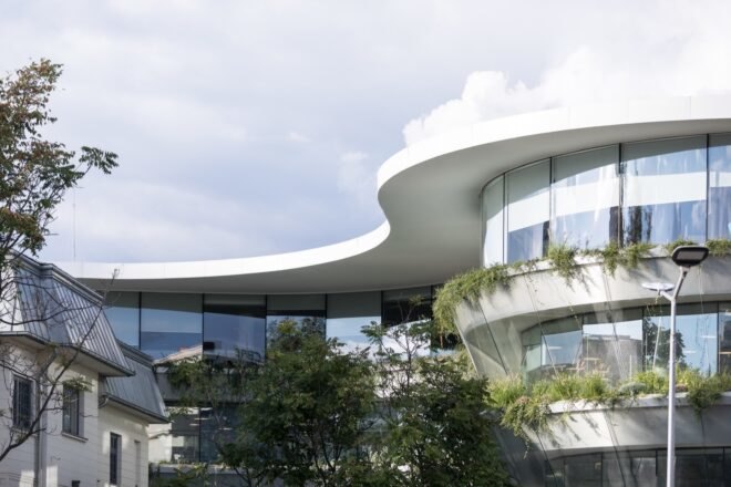 sunlight illuminates the exterior of the building with curved glass