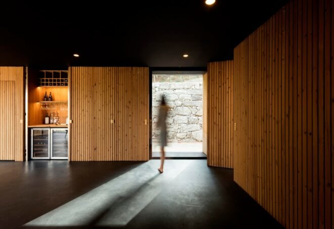 person walking inside of dark timber room