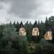 black triangular treehouses with glazed facades
