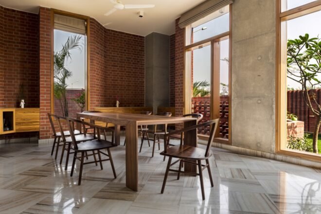 dining are with wood table and chairs along with wood accentuated floor to ceiling windows