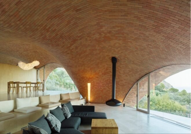 An interior living space with arched ceiling and curved windows