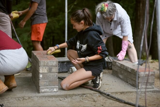 girl layering cement bricks